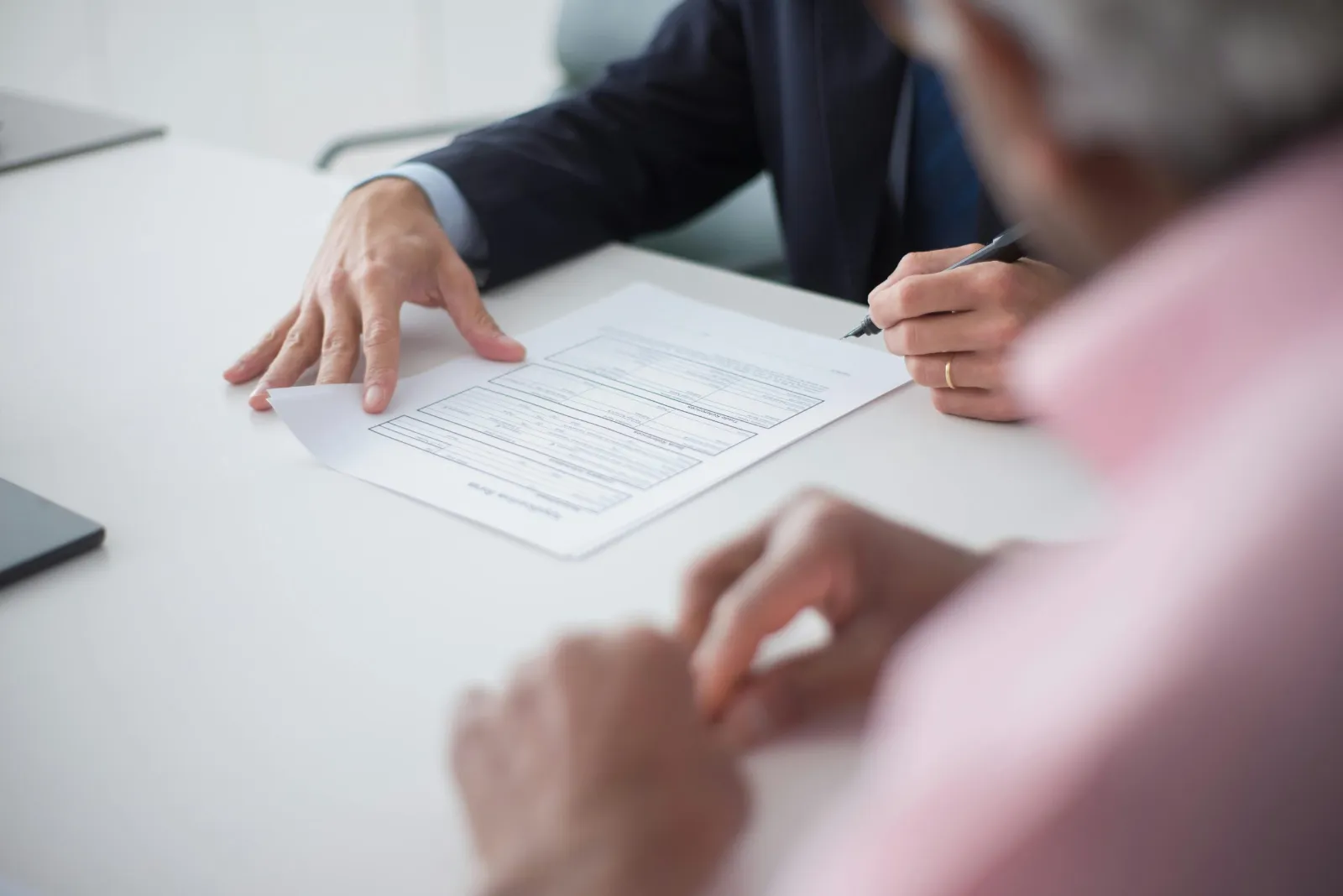 Deux professionnels signant un contrat lors d'un rendez-vous